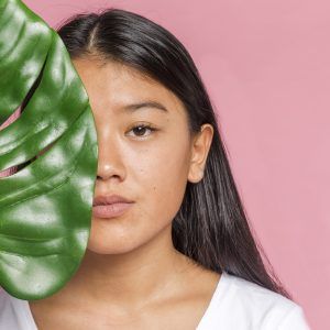 woman-with-monstera-leaf-looking-camera (1)